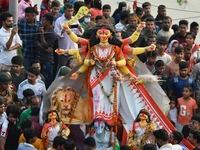 Hindu devotees immerse a clay idol of the Hindu goddess Durga in the Buriganga River on the final day of the Durga Puja festival in Dhaka, B...