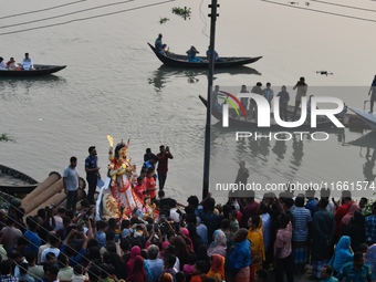 Hindu devotees immerse a clay idol of the Hindu goddess Durga in the Buriganga River on the final day of the Durga Puja festival in Dhaka, B...