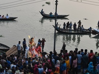 Hindu devotees immerse a clay idol of the Hindu goddess Durga in the Buriganga River on the final day of the Durga Puja festival in Dhaka, B...