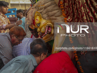 Hindu devotees immerse a clay idol of the Hindu Goddess Durga in the Buriganga River on the final day of the 'Durga Puja' festival in Dhaka,...