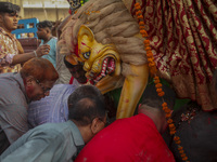 Hindu devotees immerse a clay idol of the Hindu Goddess Durga in the Buriganga River on the final day of the 'Durga Puja' festival in Dhaka,...