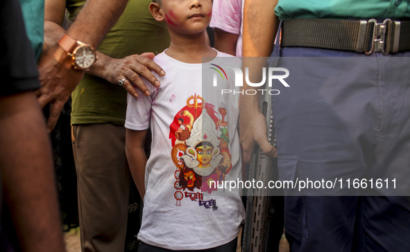 Hindu devotees immerse a clay idol of the Hindu Goddess Durga in the Buriganga River on the final day of the 'Durga Puja' festival in Dhaka,...