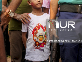 Hindu devotees immerse a clay idol of the Hindu Goddess Durga in the Buriganga River on the final day of the 'Durga Puja' festival in Dhaka,...