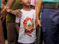 Hindu devotees immerse a clay idol of the Hindu Goddess Durga in the Buriganga River on the final day of the 'Durga Puja' festival in Dhaka,...