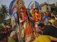 Hindu devotees immerse a clay idol of the Hindu Goddess Durga in the Buriganga River on the final day of the 'Durga Puja' festival in Dhaka,...