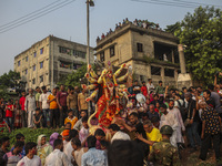 Hindu devotees immerse a clay idol of the Hindu Goddess Durga in the Buriganga River on the final day of the 'Durga Puja' festival in Dhaka,...