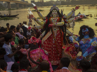 Hindu devotees immerse a clay idol of the Hindu Goddess Durga in the Buriganga River on the final day of the 'Durga Puja' festival in Dhaka,...