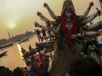 Hindu devotees immerse a clay idol of the Hindu Goddess Durga in the Buriganga River on the final day of the 'Durga Puja' festival in Dhaka,...