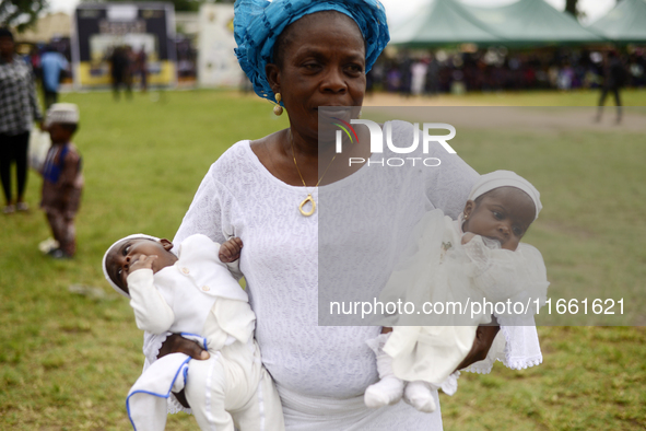 A woman carries twins during the 2024 edition of the annual World Twins Festival in Igbo-Ora, the Land of Twins, in Oyo State, Nigeria, on O...