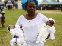 A woman carries twins during the 2024 edition of the annual World Twins Festival in Igbo-Ora, the Land of Twins, in Oyo State, Nigeria, on O...