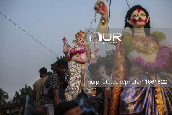 Hindu devotees immerse a clay idol of the Hindu Goddess Durga in the Buriganga River on the final day of the 'Durga Puja' festival in Dhaka,...