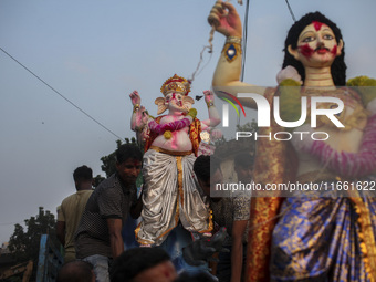 Hindu devotees immerse a clay idol of the Hindu Goddess Durga in the Buriganga River on the final day of the 'Durga Puja' festival in Dhaka,...