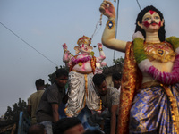 Hindu devotees immerse a clay idol of the Hindu Goddess Durga in the Buriganga River on the final day of the 'Durga Puja' festival in Dhaka,...