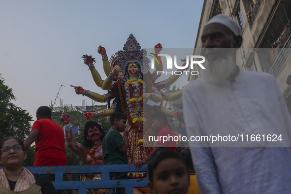 Hindu devotees immerse a clay idol of the Hindu Goddess Durga in the Buriganga River on the final day of the 'Durga Puja' festival in Dhaka,...