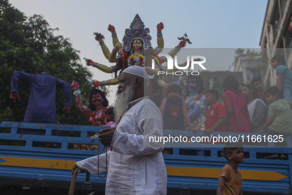 Hindu devotees immerse a clay idol of the Hindu Goddess Durga in the Buriganga River on the final day of the 'Durga Puja' festival in Dhaka,...