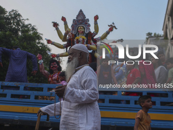 Hindu devotees immerse a clay idol of the Hindu Goddess Durga in the Buriganga River on the final day of the 'Durga Puja' festival in Dhaka,...