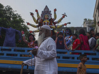 Hindu devotees immerse a clay idol of the Hindu Goddess Durga in the Buriganga River on the final day of the 'Durga Puja' festival in Dhaka,...