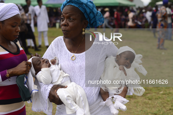 A woman carries twins during the 2024 edition of the annual World Twins Festival in Igbo-Ora, the Land of Twins, in Oyo State, Nigeria, on O...