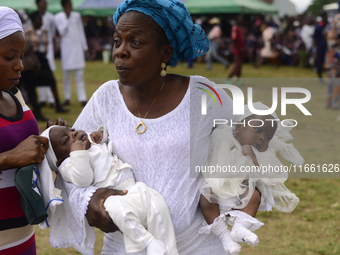 A woman carries twins during the 2024 edition of the annual World Twins Festival in Igbo-Ora, the Land of Twins, in Oyo State, Nigeria, on O...