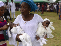 A woman carries twins during the 2024 edition of the annual World Twins Festival in Igbo-Ora, the Land of Twins, in Oyo State, Nigeria, on O...