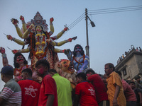 Hindu devotees immerse a clay idol of the Hindu Goddess Durga in the Buriganga River on the final day of the 'Durga Puja' festival in Dhaka,...