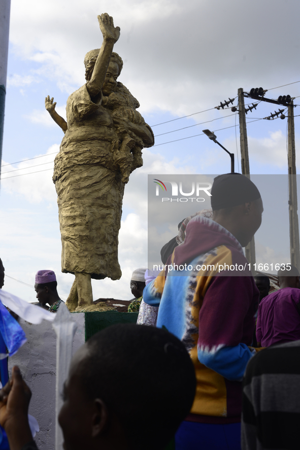 A newly unveiled statue of a woman carrying twins is surrounded by people during the 2024 edition of the annual World Twins Festival in Igbo...