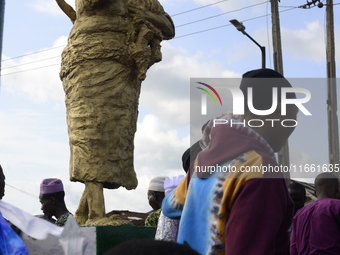 A newly unveiled statue of a woman carrying twins is surrounded by people during the 2024 edition of the annual World Twins Festival in Igbo...