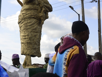 A newly unveiled statue of a woman carrying twins is surrounded by people during the 2024 edition of the annual World Twins Festival in Igbo...