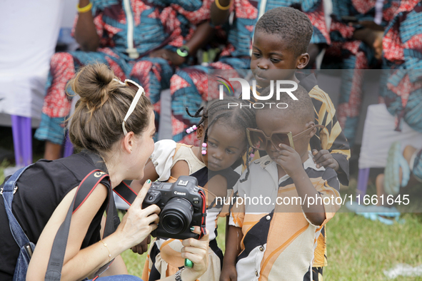 A female photographer displays images of twin children during the 2024 edition of the annual World Twins Festival in Igbo-Ora, the Land of T...