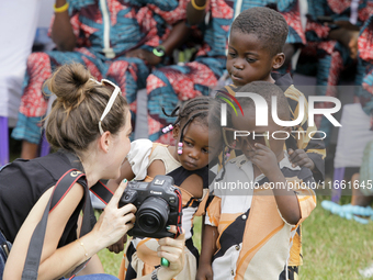 A female photographer displays images of twin children during the 2024 edition of the annual World Twins Festival in Igbo-Ora, the Land of T...