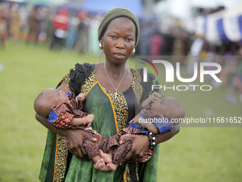 Mrs. Adebola Adeyemo carries newborn twins during the 2024 edition of the annual World Twins Festival in Igbo-Ora, the Land of Twins, in Oyo...