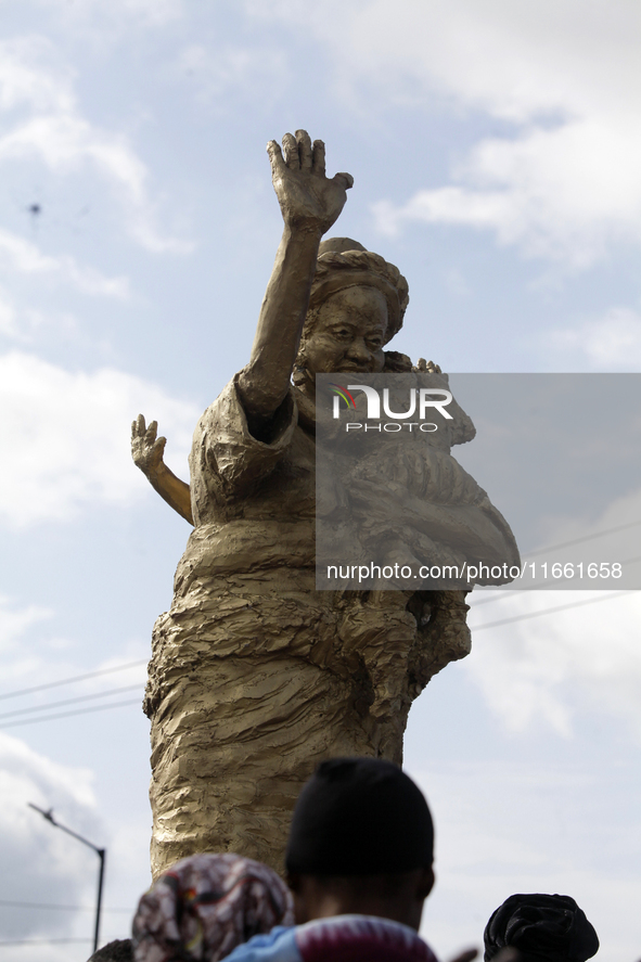 A newly unveiled statue of a woman carrying twins is surrounded by people during the 2024 edition of the annual World Twins Festival in Igbo...