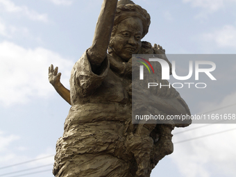 A newly unveiled statue of a woman carrying twins is surrounded by people during the 2024 edition of the annual World Twins Festival in Igbo...