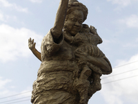 A newly unveiled statue of a woman carrying twins is surrounded by people during the 2024 edition of the annual World Twins Festival in Igbo...