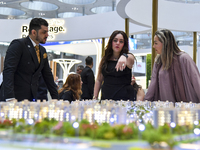 A saleswoman introduces a property to a potential buyer at the Cityscape Qatar 2024 real estate exhibition at the Doha Exhibition and Conven...