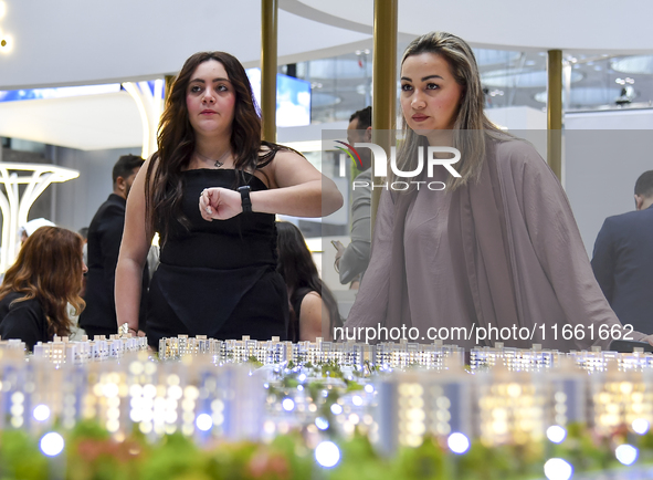 A saleswoman introduces a property to a potential buyer at the Cityscape Qatar 2024 real estate exhibition at the Doha Exhibition and Conven...