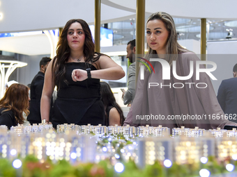 A saleswoman introduces a property to a potential buyer at the Cityscape Qatar 2024 real estate exhibition at the Doha Exhibition and Conven...