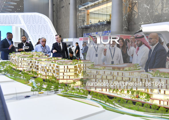 A salesman introduces property to potential buyers at the Cityscape Qatar 2024 real estate exhibition at the Doha Exhibition and Convention...