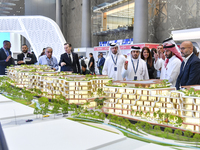 A salesman introduces property to potential buyers at the Cityscape Qatar 2024 real estate exhibition at the Doha Exhibition and Convention...