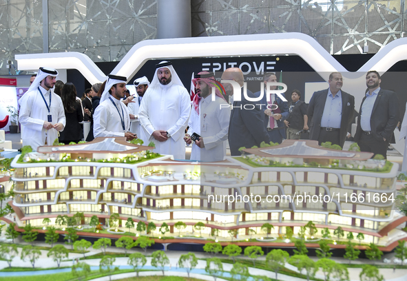 A salesman introduces property to potential buyers at the Cityscape Qatar 2024 real estate exhibition at the Doha Exhibition and Convention...