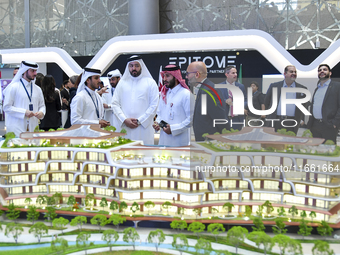 A salesman introduces property to potential buyers at the Cityscape Qatar 2024 real estate exhibition at the Doha Exhibition and Convention...