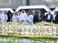 A salesman introduces property to potential buyers at the Cityscape Qatar 2024 real estate exhibition at the Doha Exhibition and Convention...