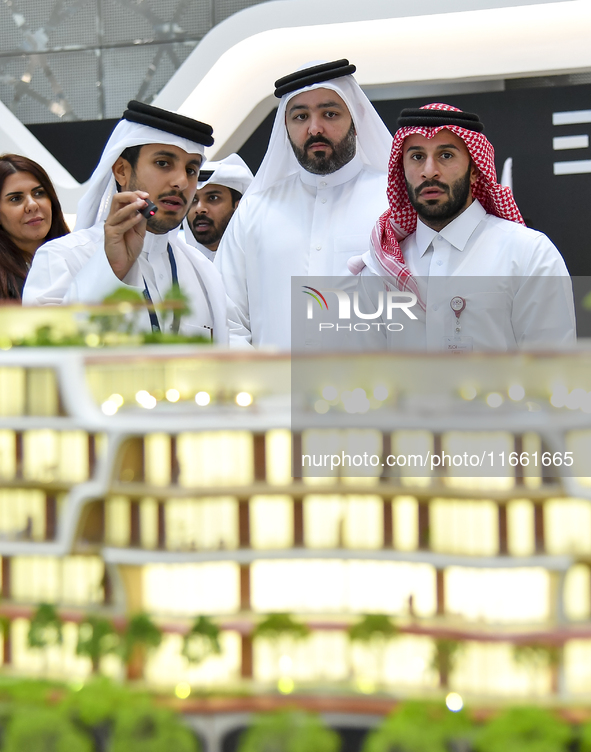 A salesman introduces property to potential buyers at the Cityscape Qatar 2024 real estate exhibition at the Doha Exhibition and Convention...