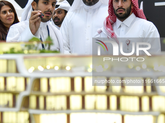 A salesman introduces property to potential buyers at the Cityscape Qatar 2024 real estate exhibition at the Doha Exhibition and Convention...