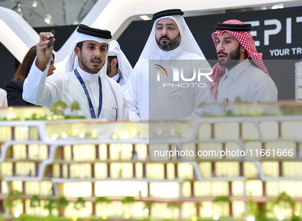 A salesman introduces property to potential buyers at the Cityscape Qatar 2024 real estate exhibition at the Doha Exhibition and Convention...