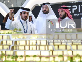 A salesman introduces property to potential buyers at the Cityscape Qatar 2024 real estate exhibition at the Doha Exhibition and Convention...