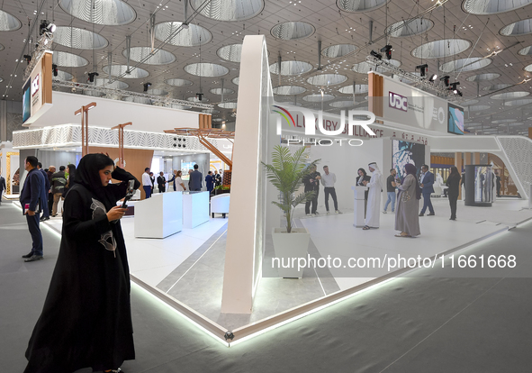 A Qatari visitor walks past a real estate pavilion at the Cityscape Qatar 2024, the real estate exhibition at the Doha Exhibition and Conven...