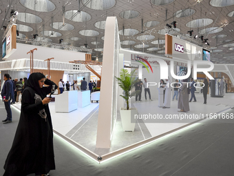 A Qatari visitor walks past a real estate pavilion at the Cityscape Qatar 2024, the real estate exhibition at the Doha Exhibition and Conven...