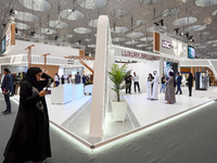 A Qatari visitor walks past a real estate pavilion at the Cityscape Qatar 2024, the real estate exhibition at the Doha Exhibition and Conven...