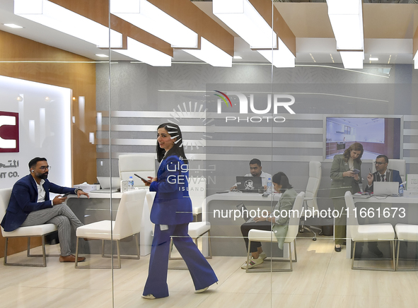 A sales representative introduces the Gewan Island real estate project to a visitor at the Cityscape Qatar 2024 real estate exhibition at th...